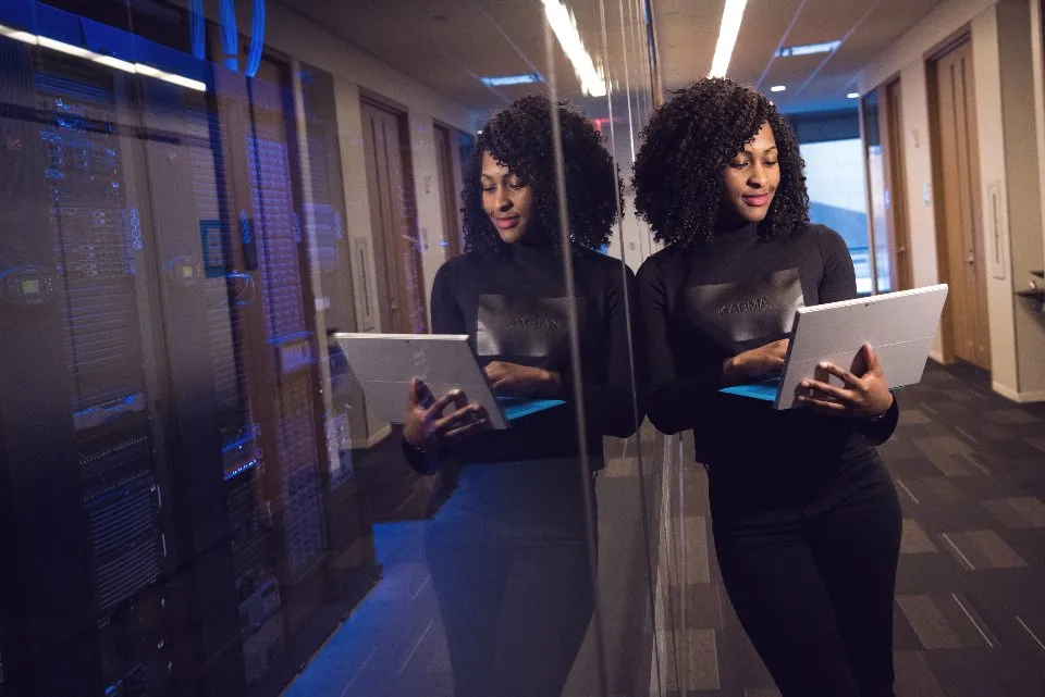 Two engineers with laptops in a server room