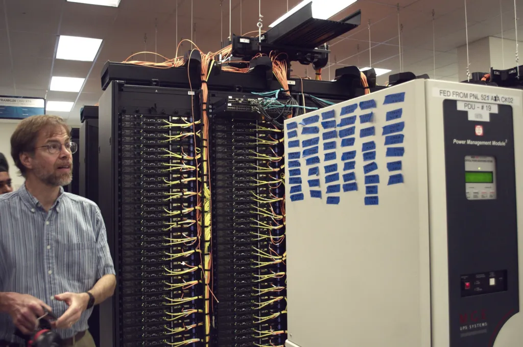 Engineer beside power equipment in a server room